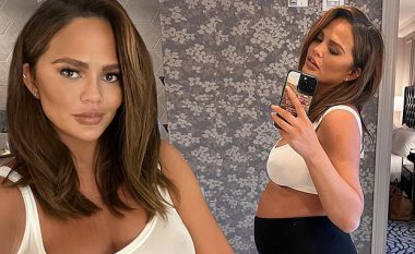 Chrissy Teigen vesh sytjena sportive të bardha teksa shfaq dekoltenë e saj të bollshme dhe tregon barkun e rrumbullakosur